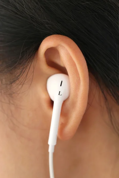 White headset in the ear of the woman in the near term.