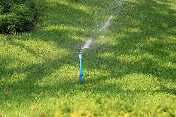 Springer está trabajando y tienen agua para el césped verde . —  Fotos de Stock