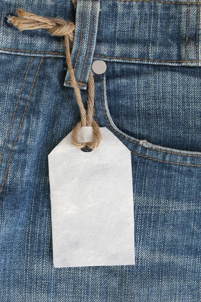 Weißes Papieretikett mit Hanfseil auf Jeans oder Jeans gebunden. — Stockfoto