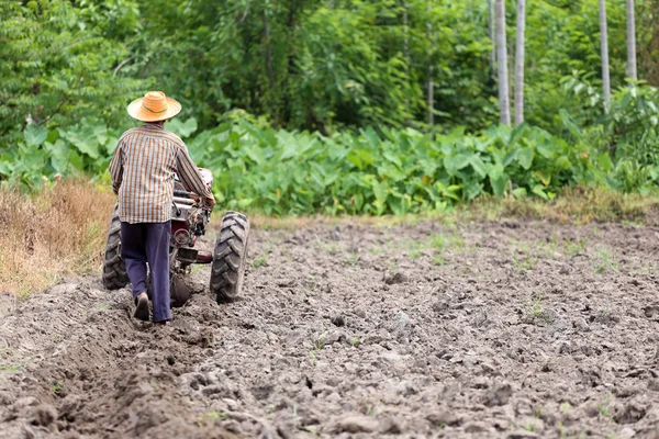 Les agriculteurs travaillent le chariot de commande pour reconditionner la culture du sol . — Photo