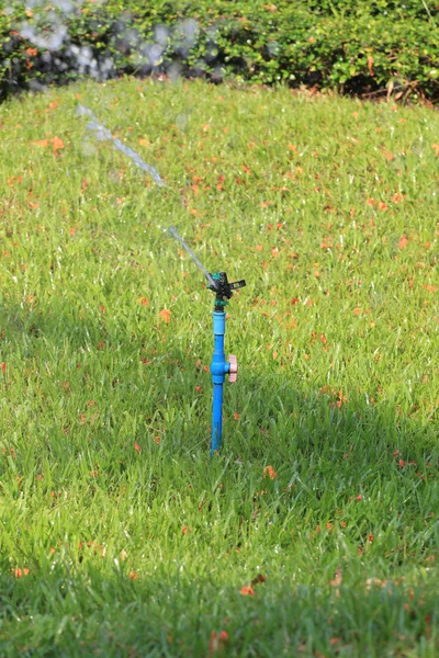 Springer is working and have water spread for green lawn. — Stock Photo, Image