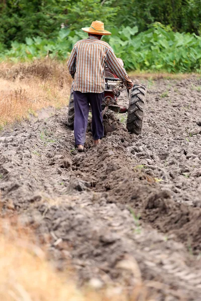 Les agriculteurs travaillent le chariot de commande pour reconditionner la culture du sol . — Photo