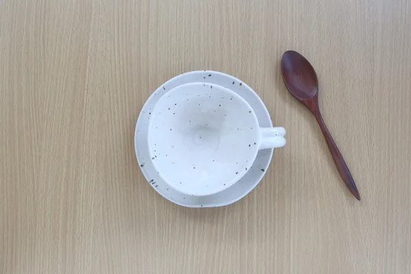 Tazza di caffè bianco e cucchiaio di legno in vista dall'alto su sfondo in legno — Foto Stock