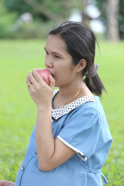 Asiático mulheres grávidas usando mão pegar maçã até comer . — Fotografia de Stock