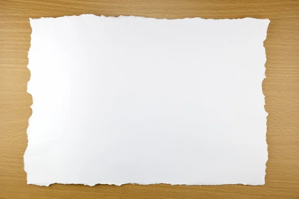 Rasgo de papel branco no fundo de madeira marrom . — Fotografia de Stock