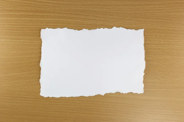 Fehér papír elszakadhat a barna fa háttér. — Stock Fotó