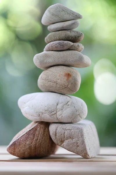 Balancear piedras rocosas o zen en suelo de madera y tener la naturaleza verde —  Fotos de Stock