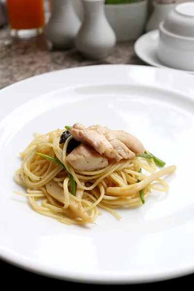 Nouilles jaunes soufflées avec viande de poulet sur un plat blanc . — Photo