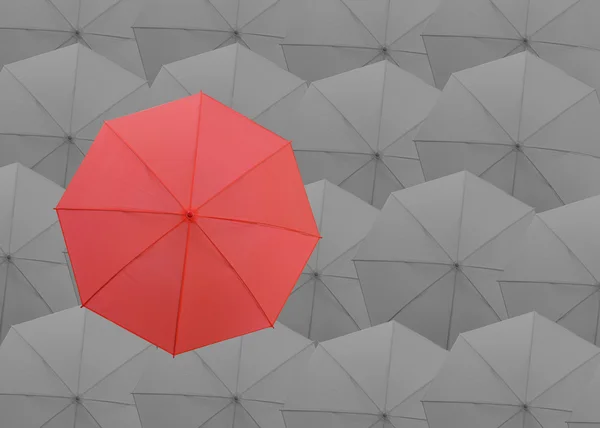 회색 우산 배경 위에 빨간 우산. — 스톡 사진