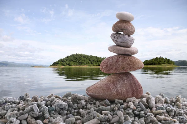 Balansera sten på högen rock med river bakgrund. — Stockfoto