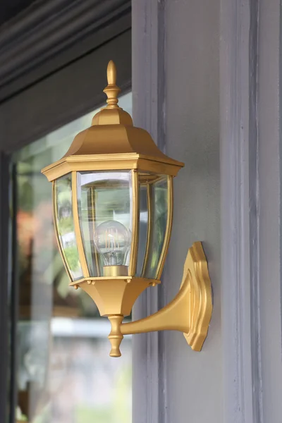 Golden lamp mounted on wall. — Stock Photo, Image