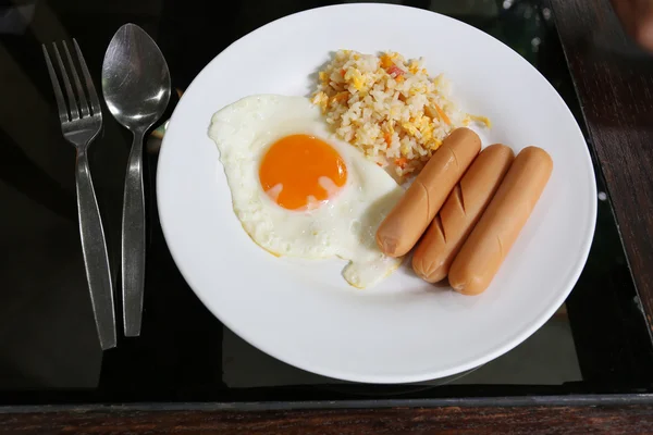 Riz frit avec oeuf frit et saucisse sur plat blanc . — Photo