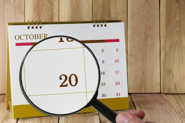Увеличительное стекло в руке на календаре вы можете посмотреть двадцатую дату — стоковое фото