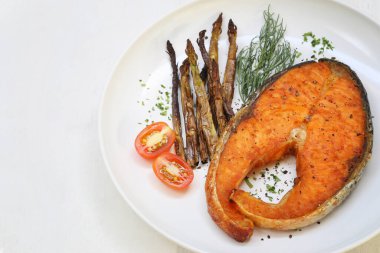 Beyaz tabakta somon bifteği ve kuşkonmaz pişirdim. Sağlığa iyi gelir..