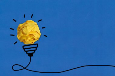 Küresel buruşuk kağıt ve el çizimi siyah çizgi ampul fikri ve kopyalama alanı.