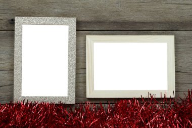 Ahşap zeminde boş eski fotoğraf çerçevesi ve Noel ve yeni yıl dekorasyonları için kırmızı püsküller..
