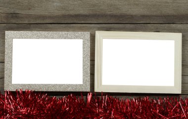 Ahşap zeminde boş eski fotoğraf çerçevesi ve Noel ve yeni yıl dekorasyonları için kırmızı püsküller..