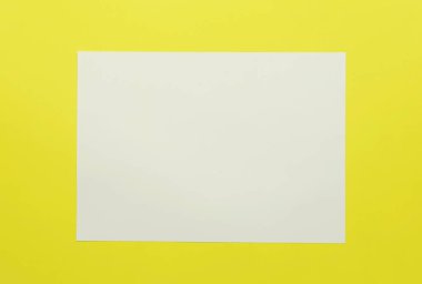 Sarı kağıt arkaplan üzerine boş beyaz kağıt ve kopyalama alanı. 