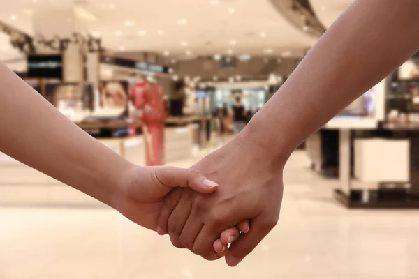 恋人たちが手をつないで 愛とバレンタインコンセプトのデザインのためのショッピングモールの背景に手をつないでいるカップル — ストック写真