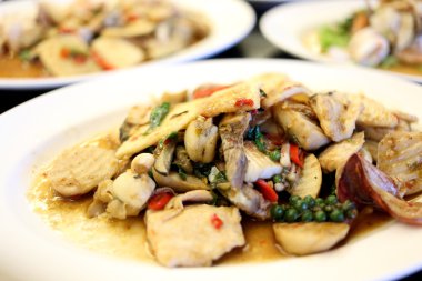 Beyaz bir tabak kızarmış karışık deniz ürünleri karıştırın.