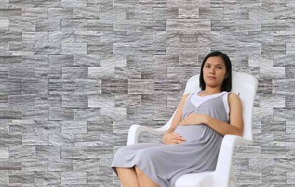 Mulheres grávidas na cadeira branca . — Fotografia de Stock