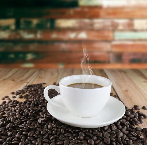 Чашка белого кофе и жареные кофейные зерна . — стоковое фото