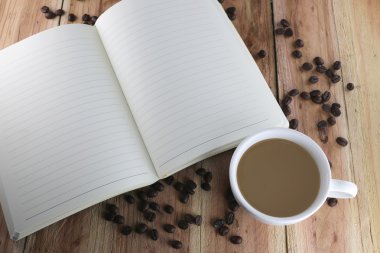 Beyaz kahve fincanı ve boş kitap.