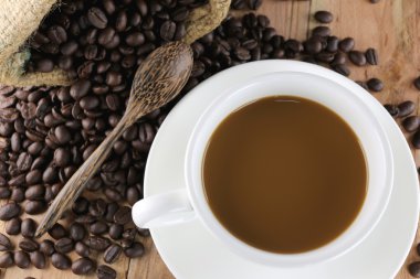 Beyaz kahve fincanı ve kavrulmuş kahve çekirdeği.