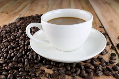 Beyaz kahve fincanı ve kavrulmuş kahve çekirdeği.