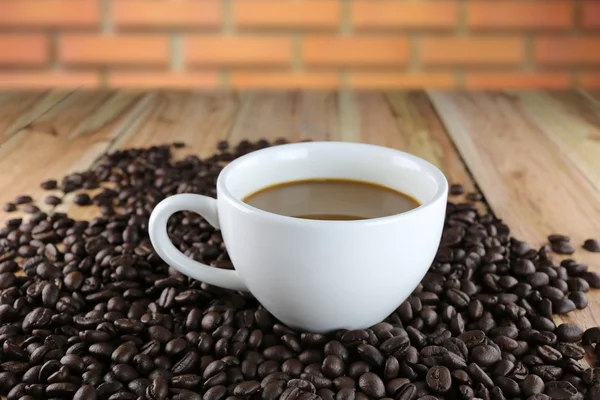 Copo de café branco e grãos de café torrados . — Fotografia de Stock