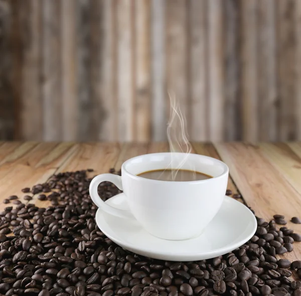 Tasse à café blanche et grains de café torréfiés . — Photo