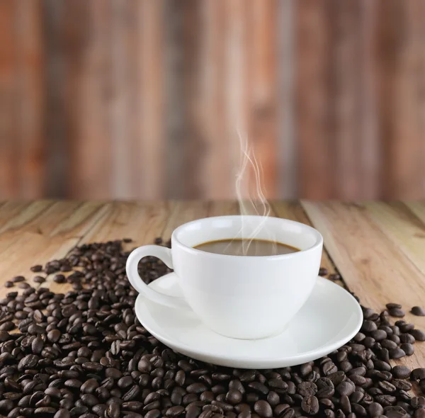 Taza de café blanco y granos de café tostados . — Foto de Stock