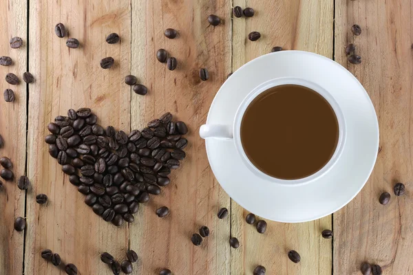 White coffee cup and coffee bean are heart shape. — Stock Photo, Image