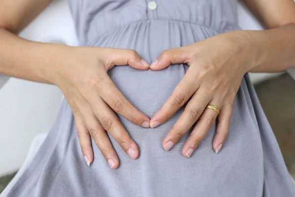 임산부 심장 모양에 그녀의 뱃속에 손을 넣어합니다. — 스톡 사진
