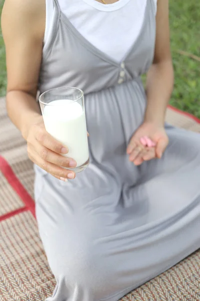 임산부 우유와 비타민 알 약의 한 잔을 손에 — 스톡 사진