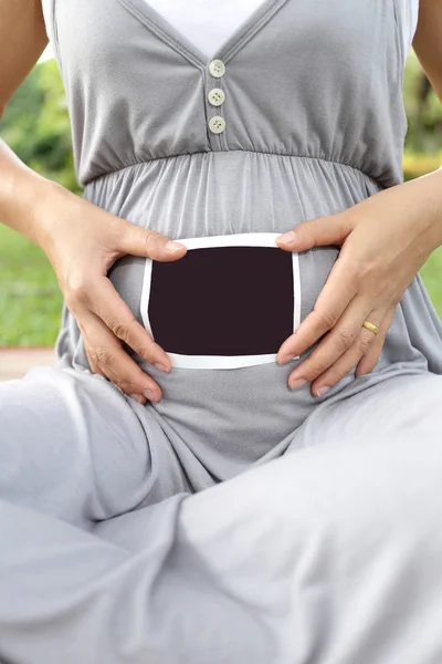 Les femmes enceintes montrent l'image de film d'échographie sur son ventre . — Photo
