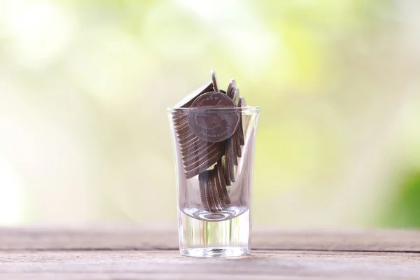 Pièce d'argent en verre est placé sur un plancher de bois avec bok coloré — Photo