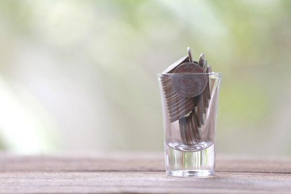 silver coin in glass is placed on a wood floor with colorful bok