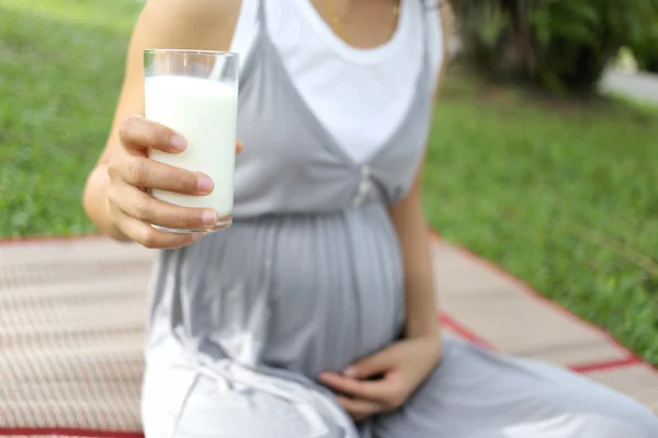 Mulheres grávidas têm um copo de leite na mão . — Fotografia de Stock