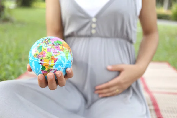 Schwangere zeigen Globus-Modell in der Hand. — Stockfoto