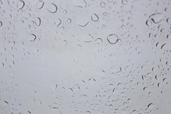 Chuva cai sobre fundo de vidro. — Fotografia de Stock