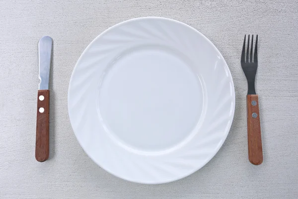 Bílé nádobí s vidličkou a nožem. — Stock fotografie