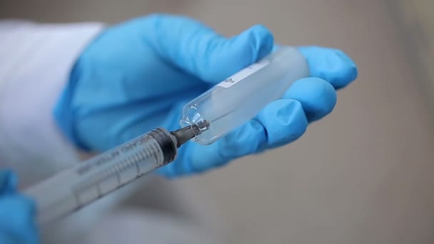 Doctors hand in the gloves wih syringe and ampoule — Stock Video