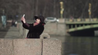 Siyah şapkalı güzel kadınlar Avrupa şehri Bridge'de selphy yapar.