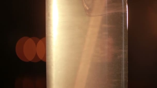 Бегущие пузырьки в стакане ледяного алкогольного коктейля с вишней — стоковое видео