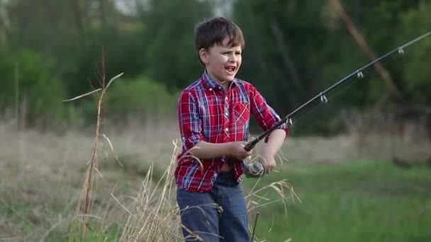 Six year old boy catches a fish. his mom kisses him — Stock Footage Six year old boy catches a fish. his mom kisses him Royalty Free Stock Footage