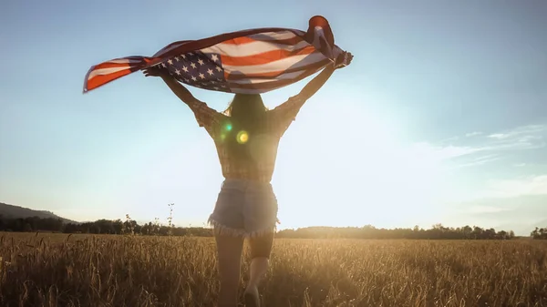 Mujer joven ondea una bandera americana — Foto de Stock