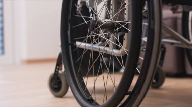 Oturma odasında tekerlekli sandalyedeki adam.