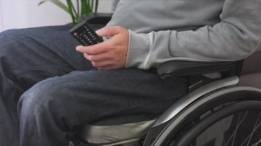 Tekerlekli sandalyedeki adam televizyon izliyor.