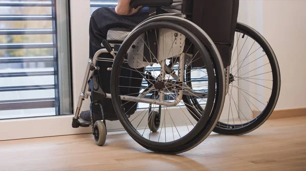 Hombre en silla de ruedas en sala de estar — Foto de Stock